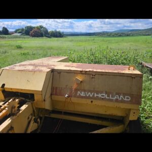 Second-hand New Holland baler in working condition on a South African farm, used for producing compact square hay bales.