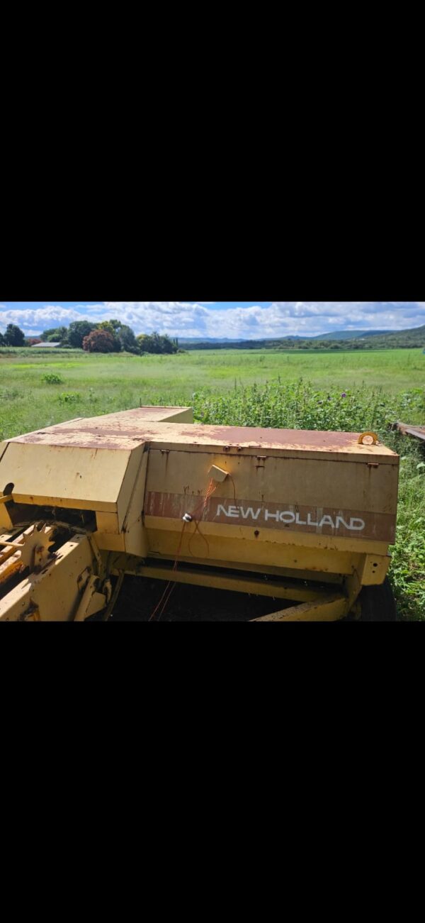 Second-hand New Holland baler in working condition on a South African farm, used for producing compact square hay bales.